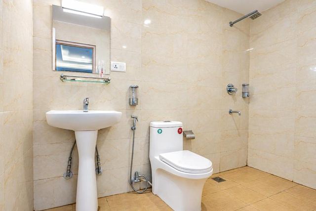 Tiled bathroom with a basin, toilet and hot shower