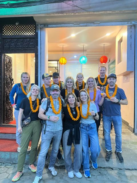 Guests with marigold garlands at the hotel entrance in the evening
